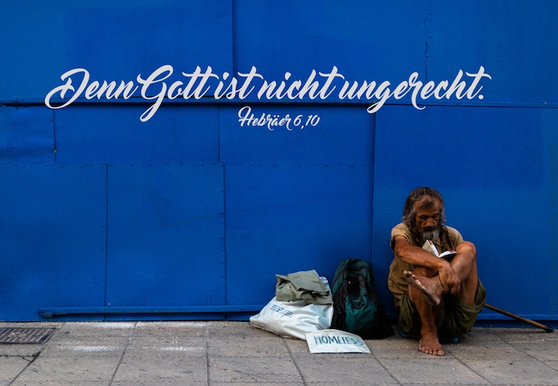 Obdachloser vor blauer Wand