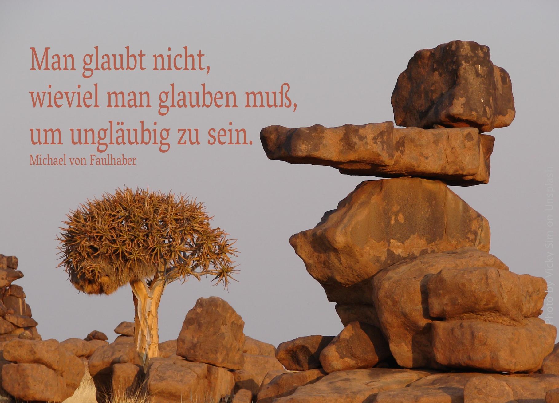 Aufeinander liegende Felsen in der Steppe mit Dornenbaum