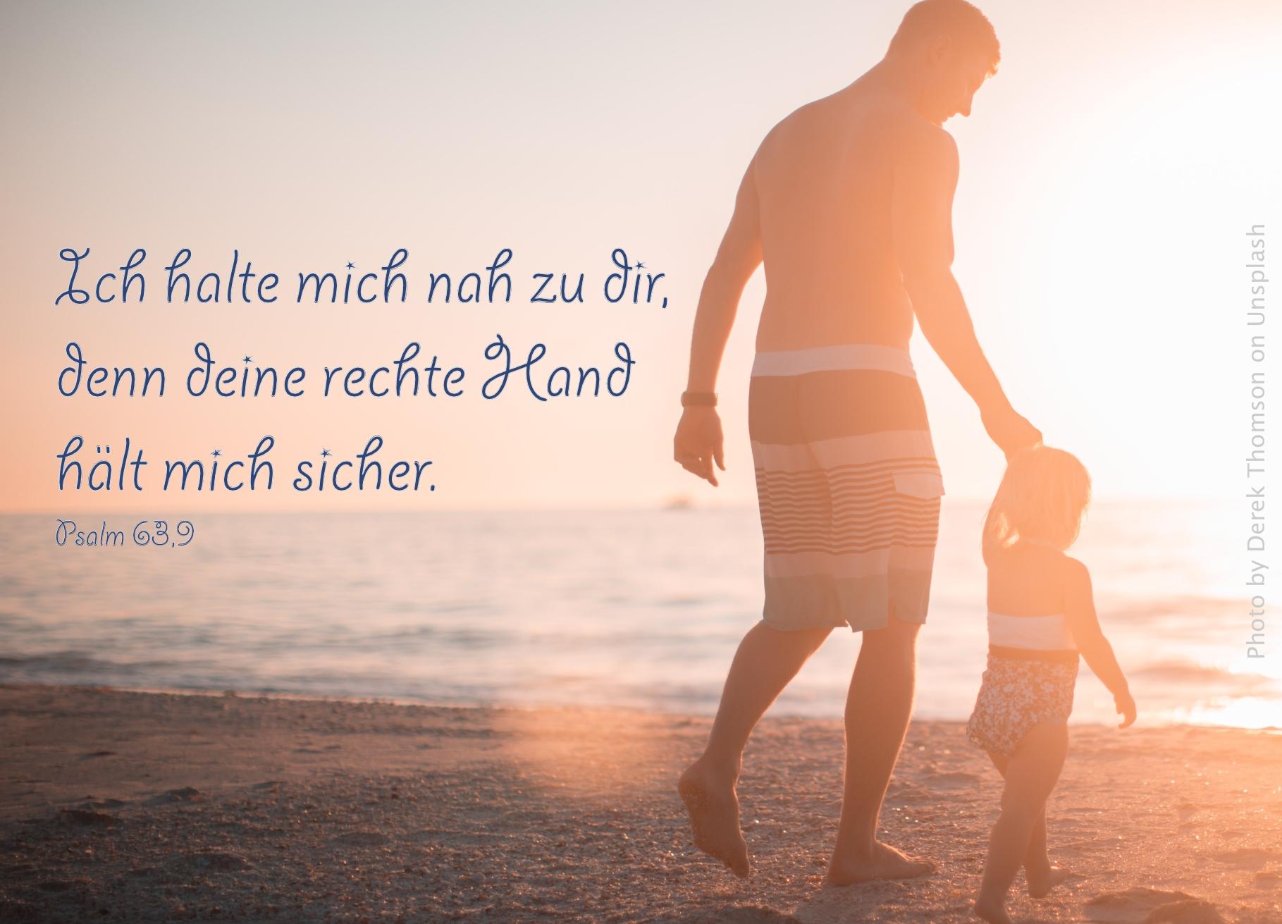 Mann mit Kind an der Hand am Strand